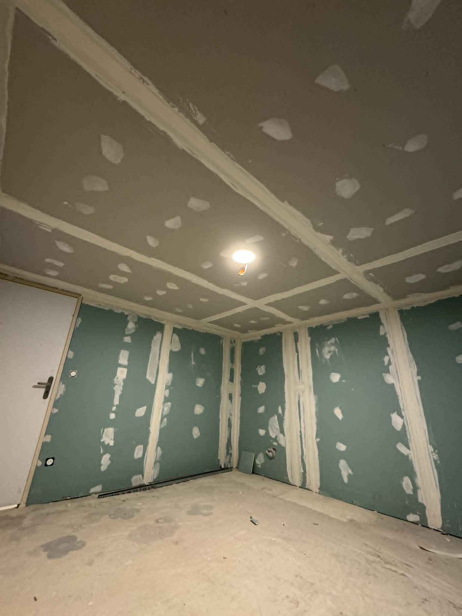 Plaques de plâtre hydrofuges vertes aux murs et plafond jointés dans une pièce à Besançon, chantier RUSHITI Rénovation